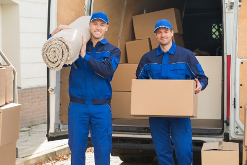 Local movers handling boxes and furniture near a Belsizepark flat