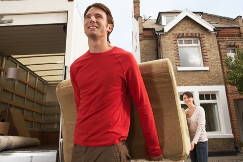 Removal crew planning access and carrying items down stairs in Belsize Park