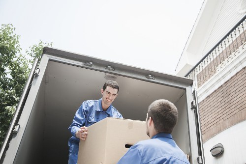 Professional movers transporting furniture from a flat in Belsizepark